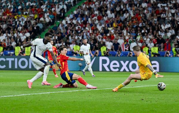 Mikel Oyarzabal of Spain (in red) shoots past England goalkeeper Jordan Pickford and scores the winning goal in the UEFA Euro 2024 final in Berlin, on July 14, 2024. (Dan Mullan/Getty Images)