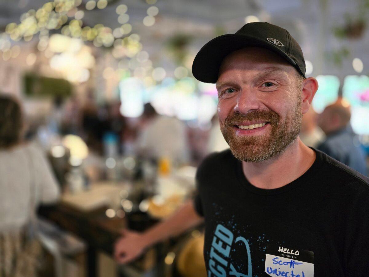 Unjected.com marketing director Scott Armstrong checks in guest during a social mixer for unvaccinated singles in Phoenix, Ariz., on July 15, 2024. (Allan Stein/The Epoch Times)
