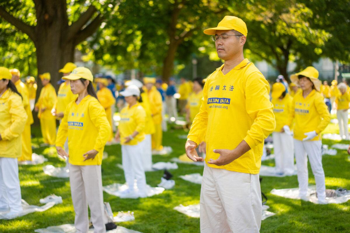 Falun Gong practitioners perform meditative exercises during an event held at Queen's Park in Toronto on July 20, 2024. The event commemorates the 25th anniversary of the Chinese regime's persecution of Falun Gong. (Evan Ning/ The Epoch Times)