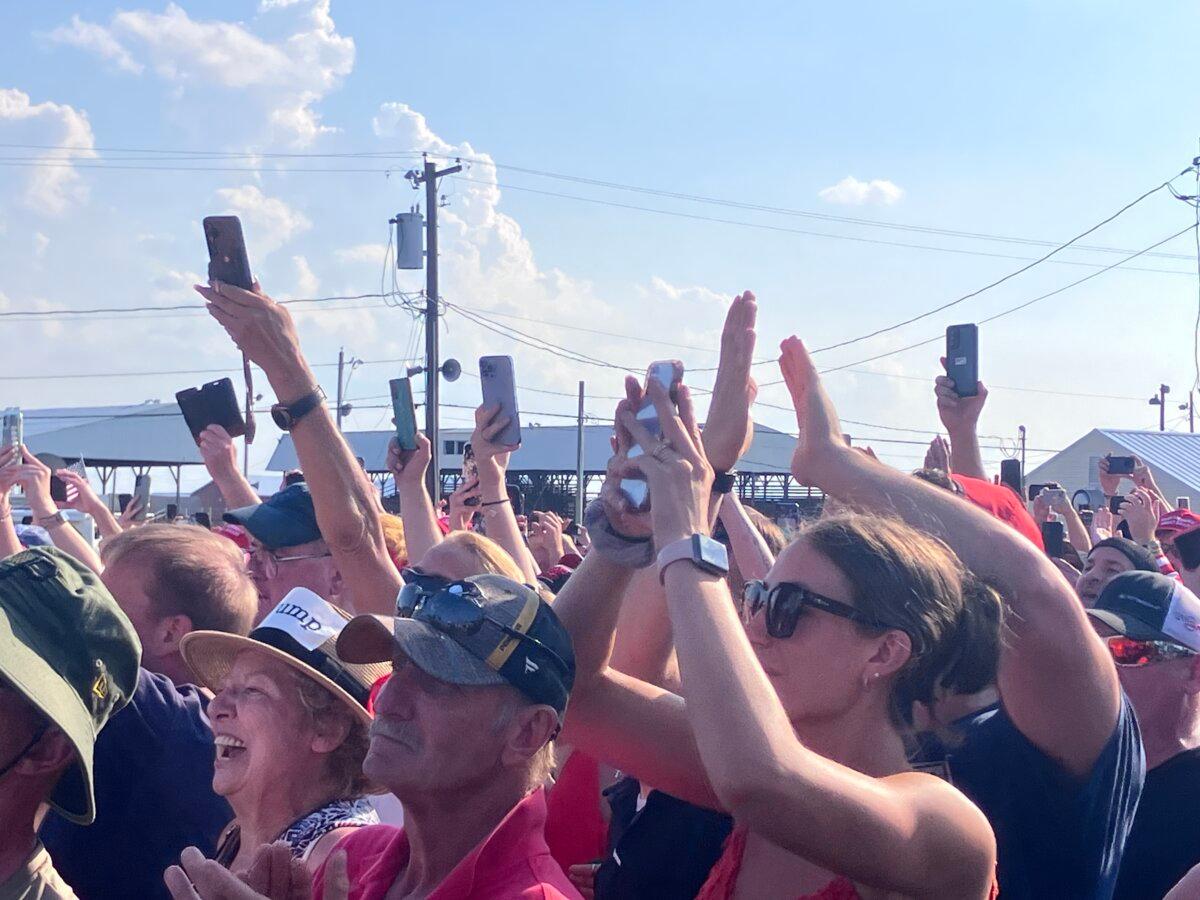 Trump fans smile and take photos just before he began his speech and was targeted by a would-be assassin in Butler, Pa., on July 13, 2024. (Janice Hisle/The Epoch Times)
