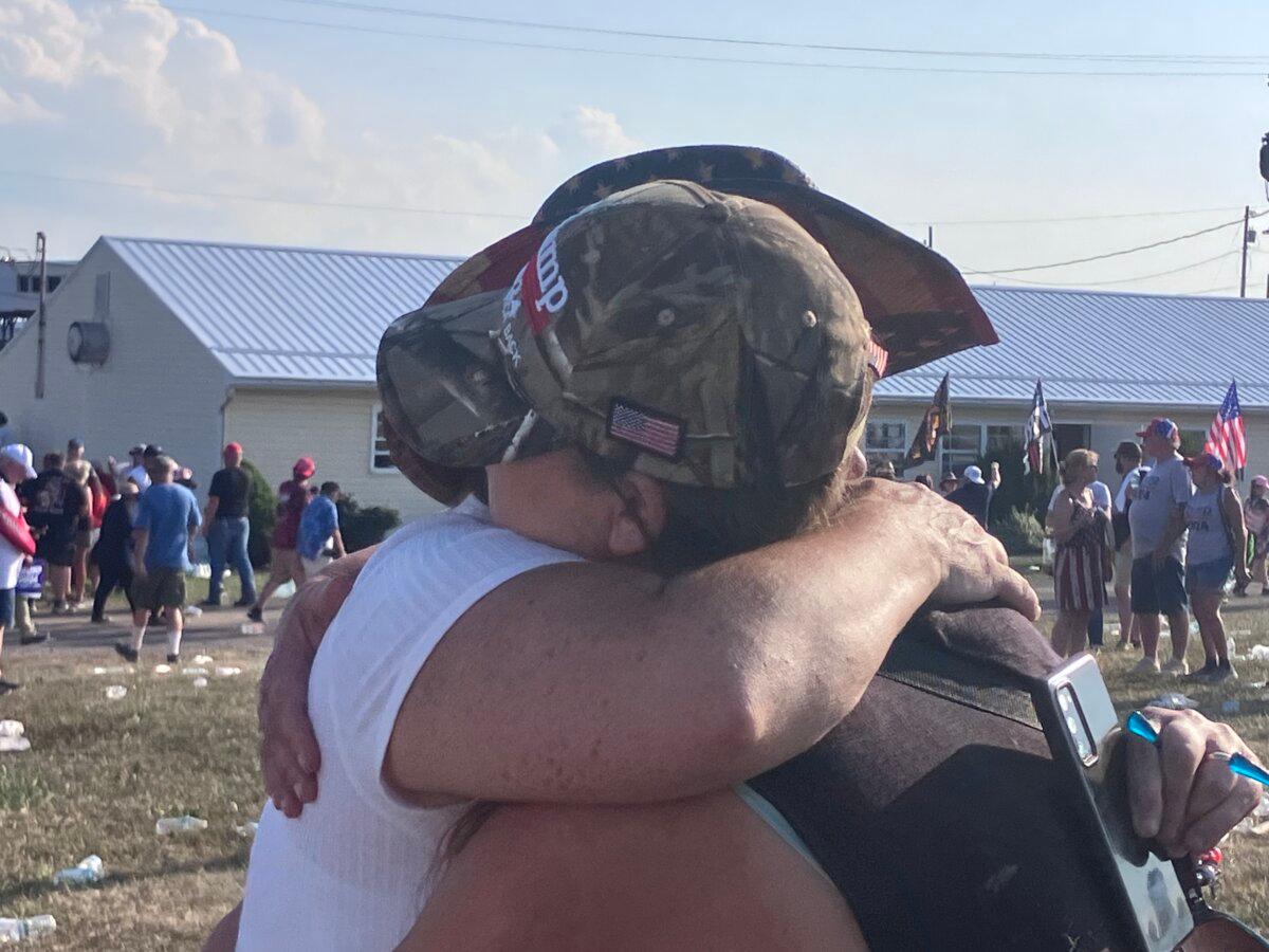 Rally goers comfort each other in the aftermath of the assassination attempt on former President Donald Trump in Butler, Pa., on July 13, 2024. (Janice Hisle/The Epoch Times)