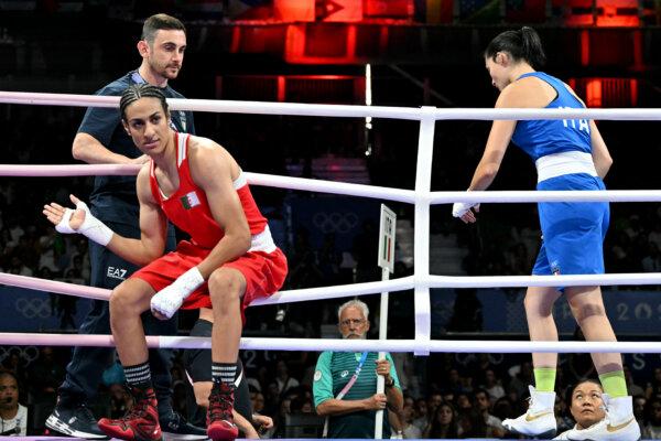 Algeria's Imane Khelif (in red) and Italy's Angela Carini leave after their women's 66kg preliminaries round of 16 boxing match during the Paris 2024 Olympic Games at the North Paris Arena in Villepinte on Aug. 1, 2024. (Mohd Rasfan/AFP via Getty Images)