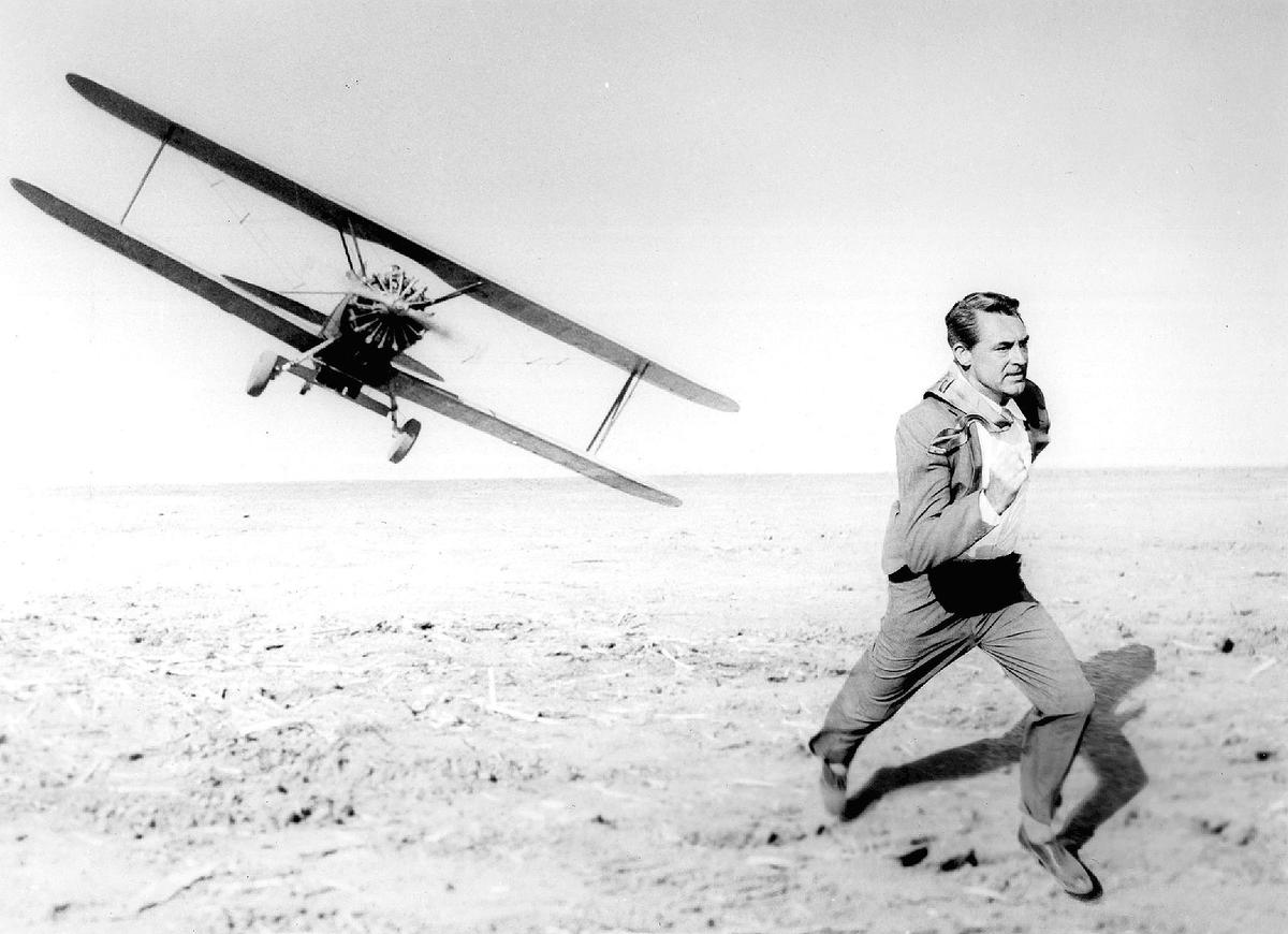 Roger Thornhill (Cary Grant) runs from a crop-dusting plane, in "North by Northwest." (Public Domain)