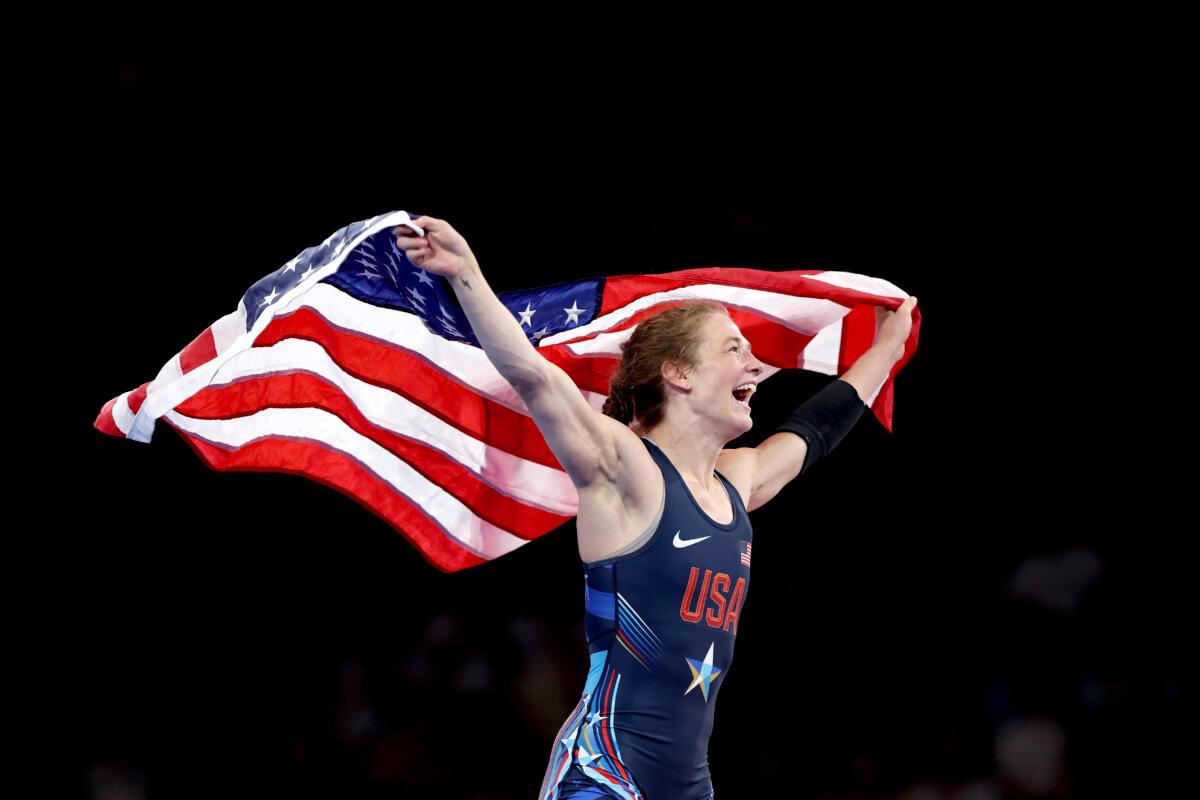 Sarah Ann Hildebrandt of Team United States celebrates with the United States flag following victory in the wrestling women’s freestyle 50kg gold medal match against Yusneylis Guzman Lopez of Team Cuba on day twelve of the Olympic Games at Champs-de-Mars Arena in Paris on Aug. 7, 2024. (Sarah Stier/Getty Images)