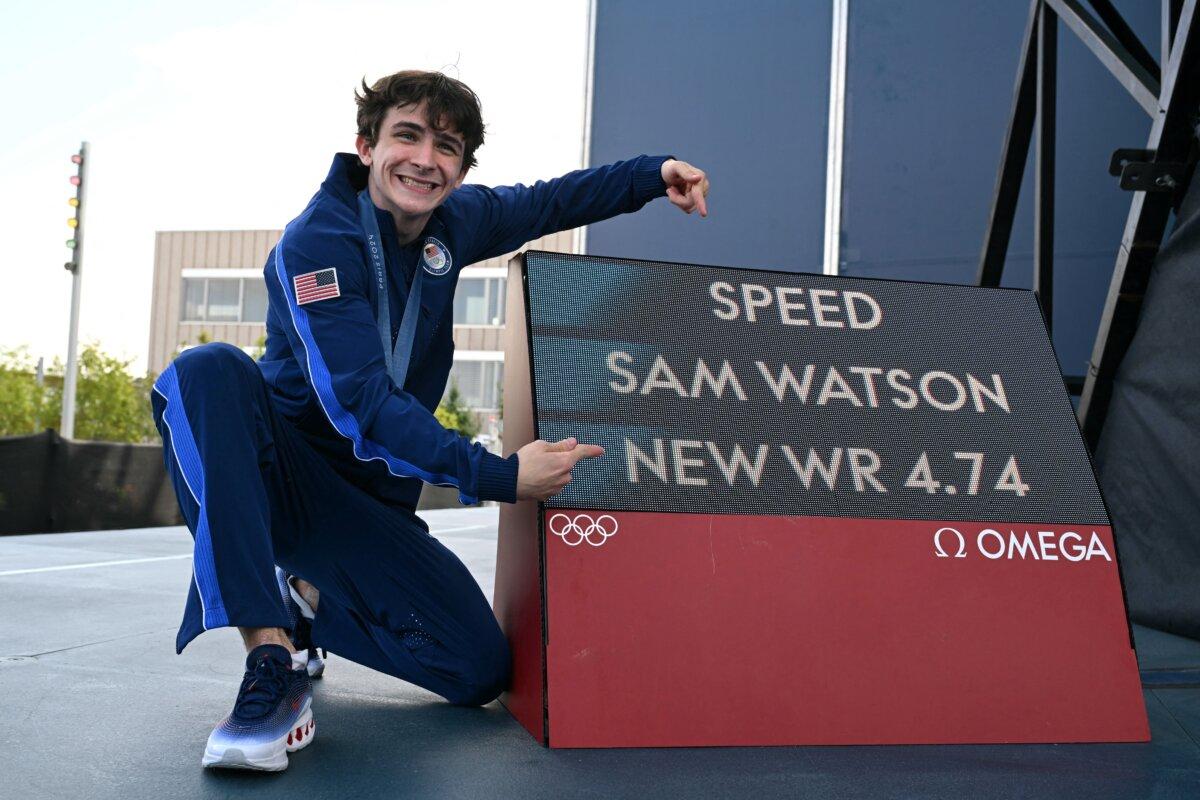 Team USA's Sam Watson poses with a sign after setting a new World Record in the men's sport climbing speed event during the Paris Olympic Games at Le Bourget Sport Climbing Venue in Le Bourget in Le Bourget, France, on Aug. 8, 2024. (Jonathan Nackstrand/AFP via Getty Images)