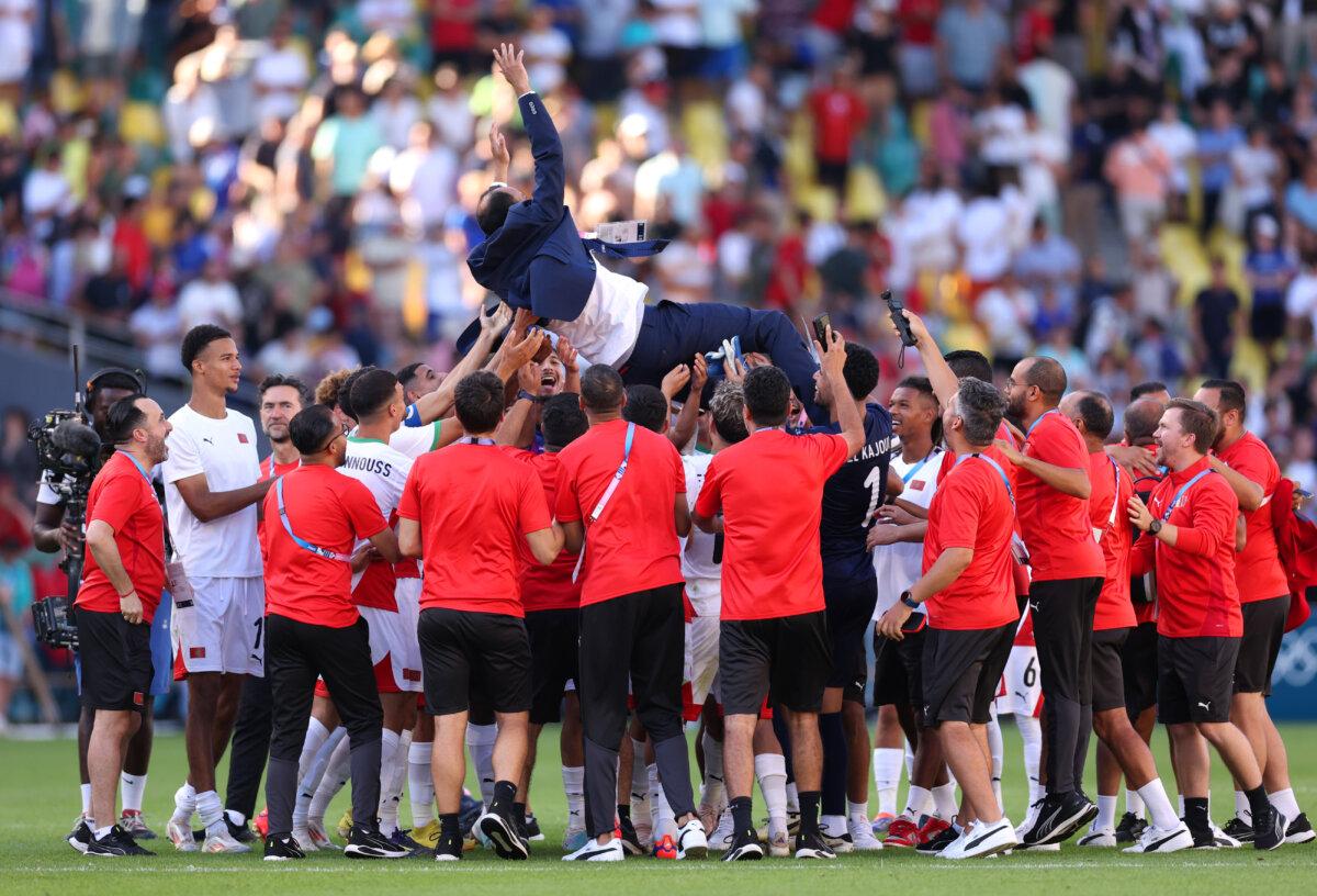 Players of Team Morocco celebrate victory with their head coach, Tarik Sektioui, after the men's bronze medal match between Egypt and Morocco during day 13 of the Olympic Games at Stade de la Beaujoire in Nantes, France, on Aug. 8, 2024 (Robert Cianflone/Getty Images)
