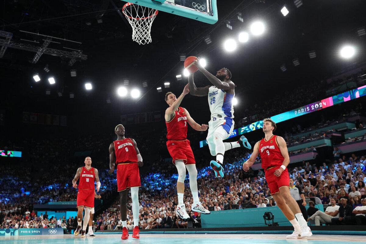 Mathias Lessort of Team France goes up for a basket past Johannes Voigtmann of Team Germany during a Men's basketball semifinals match between Team France and Team Germany on day 13 of the Olympic Games at Bercy Arena in Paris on Aug. 8, 2024. (Ezra Shaw/Getty Images)