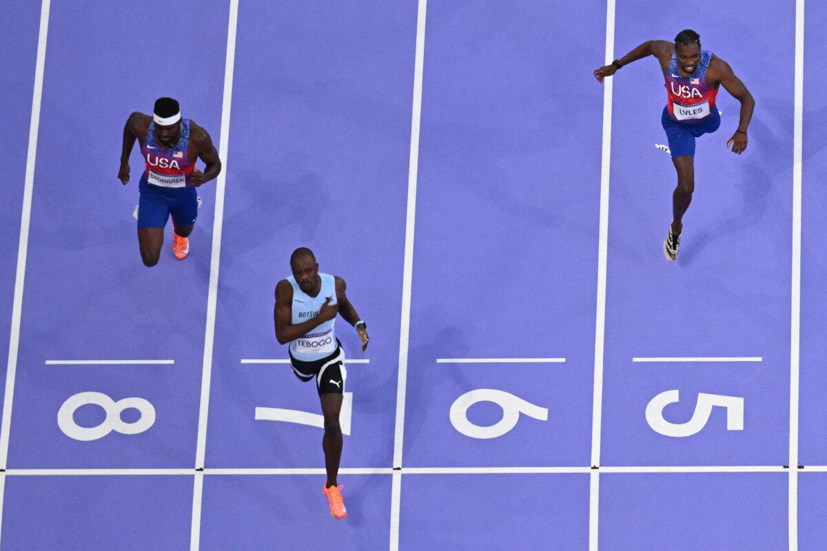 Botswana's Letsile Tebogo (C) crosses the finish line ahead of US' Kenny Bednarek (L) and Noah Lyles (R) to win the men's 200m final of the athletics event at the Olympic Games at Stade de France in Saint-Denis, north of Paris, on Aug. 8, 2024. (Jewel Samad/AFP via Getty Images)