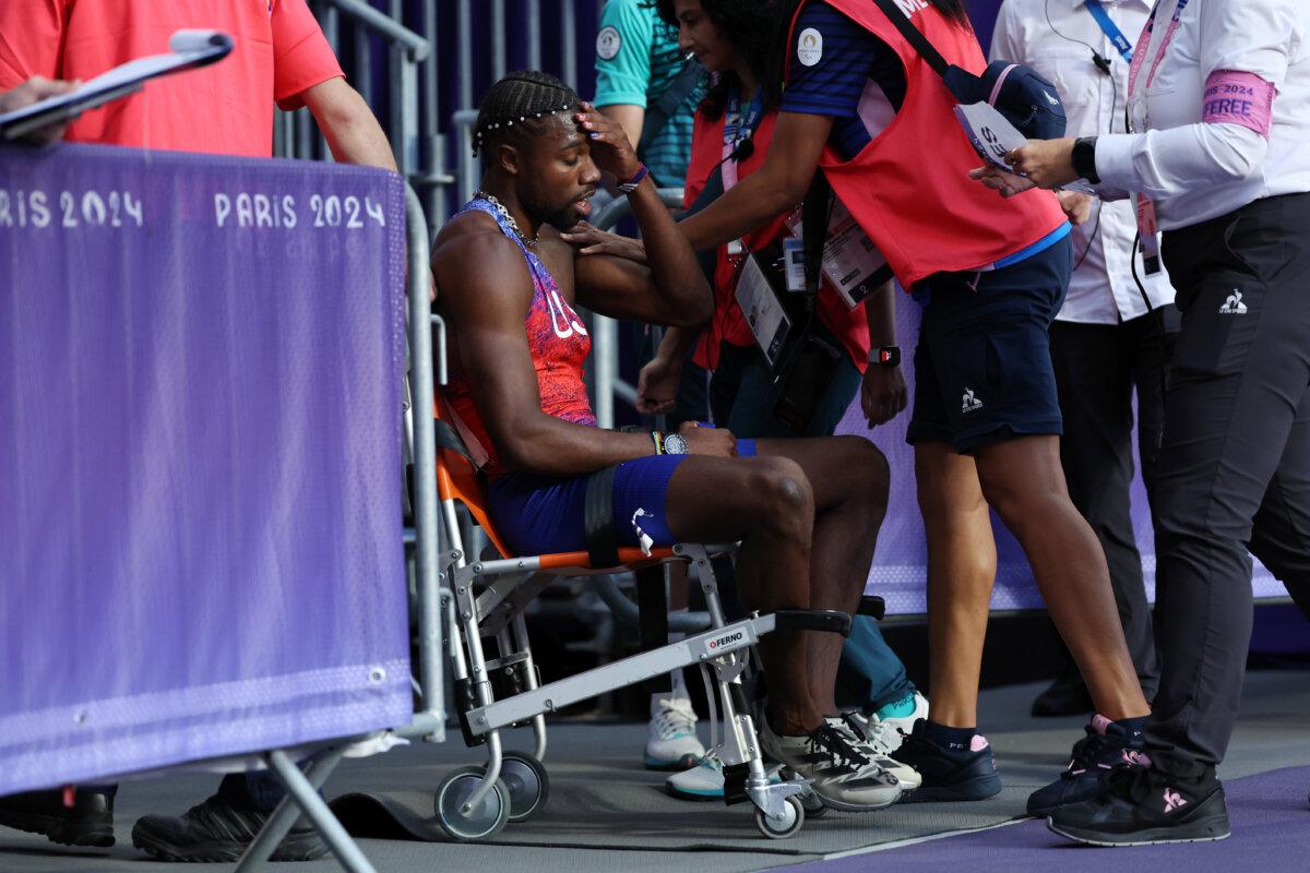 Bronze medalist Noah Lyles of Team United States is taken off from the track with a wheelchair after competing in the men's 200m final on day 13 of the Olympic Games at Stade de France in Paris on Aug. 8, 2024. (Hannah Peters/Getty Images)