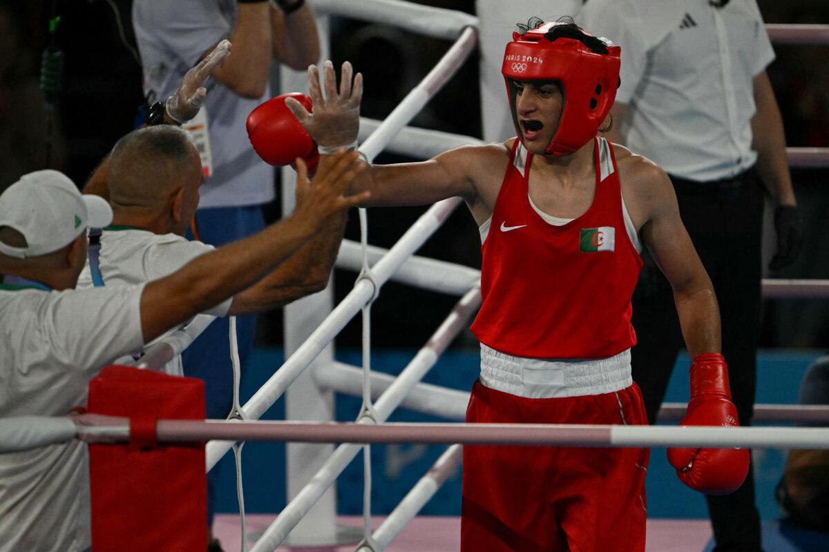 Algeria's Imane Khelif reacts after beating China's Yang Liu (Blue) in the women's 66 kg final boxing match during the Olympic Games at the Roland-Garros Stadium in Paris on Aug. 9, 2024. (Mauro Pimentel/AFP via Getty Images)