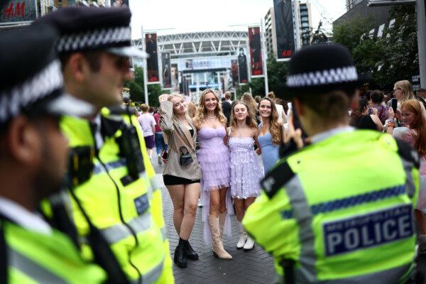 A police officer takes a photograph of fans of American mega-star Taylor Swift as they gather on Olympic Way outside Wembley Stadium in London on Aug. 15, 2024. (Henry Nicholls/AFP via Getty Images)