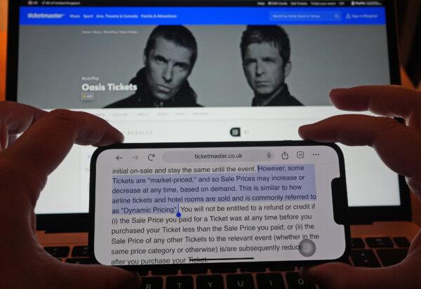 A section of Ticketmaster's purchase policy explaining dynamic pricing highlighted on a phone, with the Ticketmaster website displayed in the background, showing the options for purchasing Oasis tickets, in London on Sept. 2, 2024. (Yui Mok/PA)