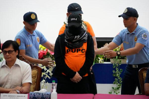 Apollo Quiboloy (C), a preacher accused of sexual abuse and human trafficking, is escorted beside Philippine Interior Secretary Benhur Abalos (L) during a news conference at the Camp Crame police headquarters in Quezon City, Philippines, on Sept. 9, 2024. (AP Photo/Aaron Favila)