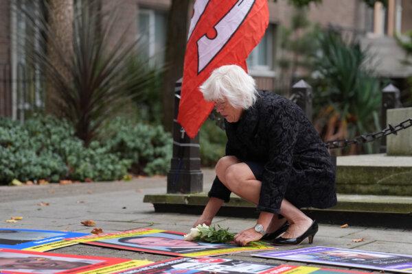 Melanie Leahy, whose 20-year-old son, Matthew, died in November 2012 while a patient at the Linden Centre mental health facility in Chelmsford, lays some flowers on a picture of him outside the Lampard Inquiry at Chelmsford Civic Centre before the start of the hearings into the deaths of mental health inpatients in Essex on Sept. 9, 2024. (PA)