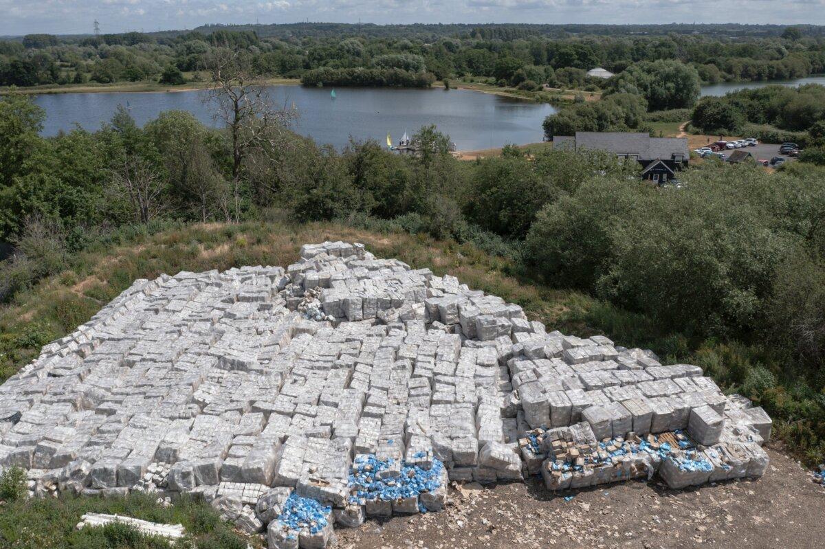 Boxes of PPE are discarded on an area of land near Testwood Lakes nature reserve in Calmore, England, on June 19, 2023. The stacks of boxes are thought to include unused aprons and masks procured during the COVID-19 pandemic. (Dan Kitwood/Getty Images)