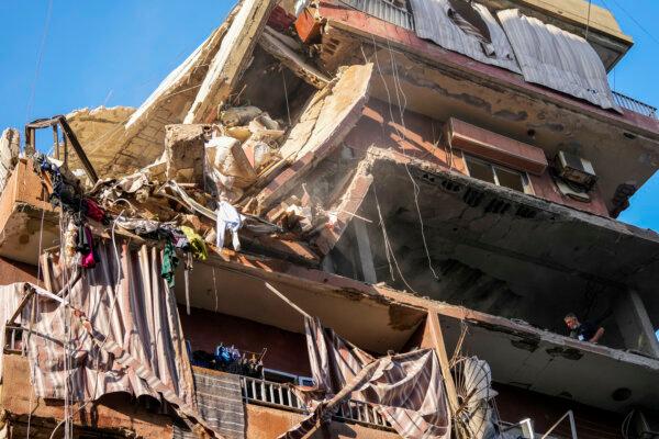 Residents check a partially destroyed building at the site of an Israeli airstrike in Beirut's southern suburbs on Sept. 24, 2024. (AP Photo/Hassan Ammar)