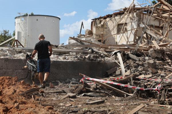 A man and a dog check the rubble of a destroyed building in the aftermath of an Iranian missile attack in Hod HaSharon, Israel, on Oct. 2, 2024. (Jack Guez/AFP via Getty Images)
