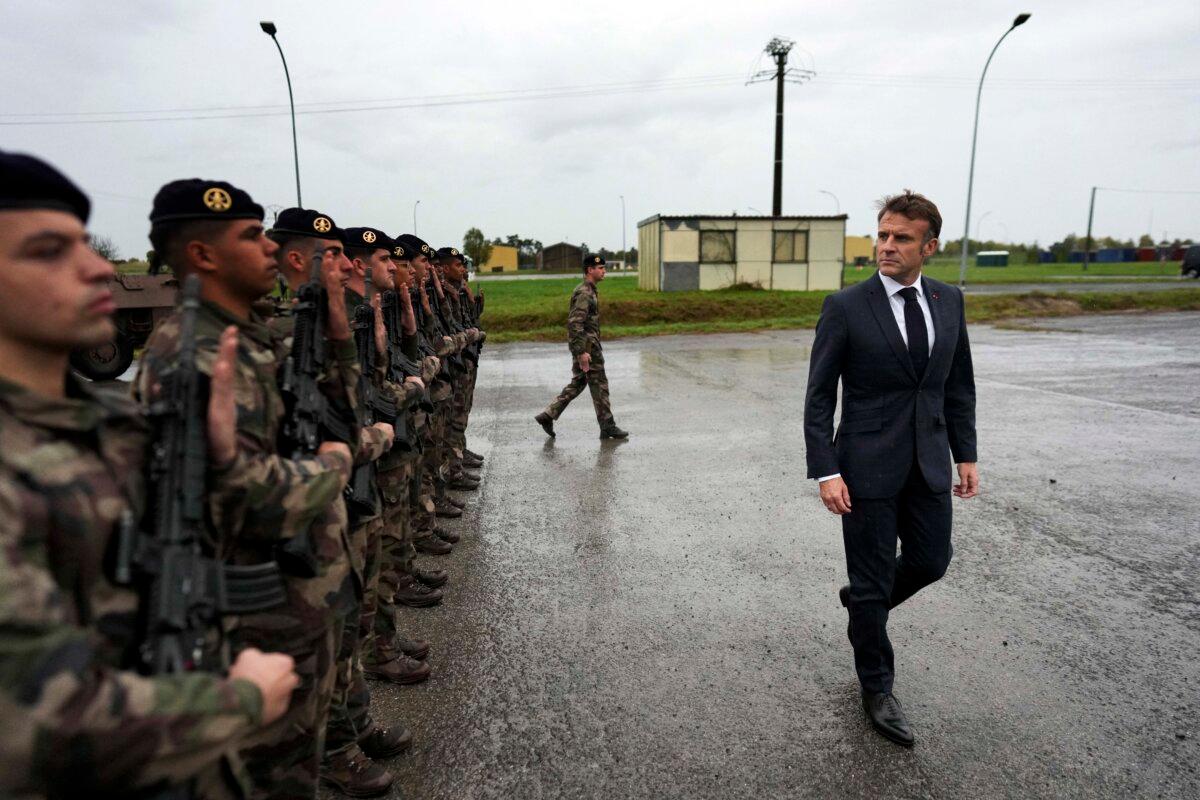 French President Emmanuel Macron (R) reviews French troops during a visit to a military camp in eastern France on Oct. 9, 2024. (Thibault Camus/AFP via Getty Images)