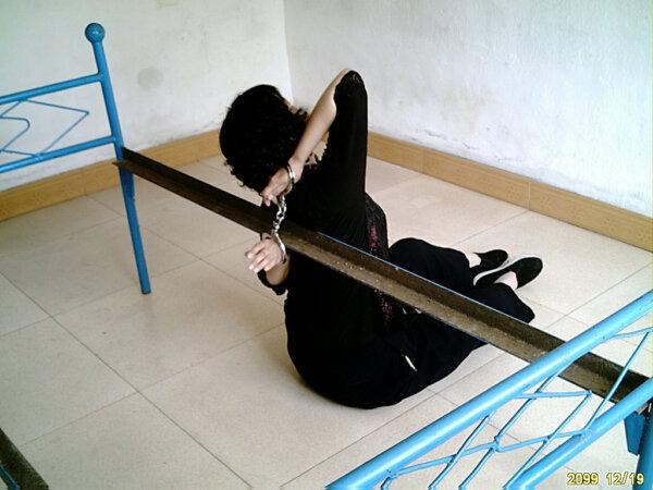 Illustration of a torture method used by the Chinese regime to persecute Falun Gong practitioners, where hands are cuffed to the back for long hours, in an undated photo. (Courtesy of Minghui.org)