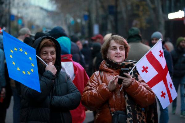 Two women hold an EU and a Georgian national flag during a protest outside the parliament building in Tbilisi, Georgia, on Dec. 1, 2024. (Zurab Tsertsvadze/AP)