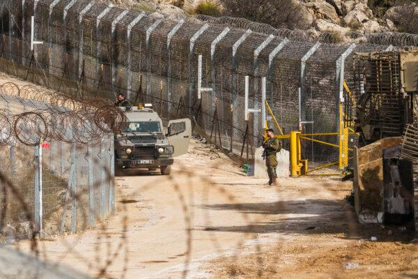 An Israeli soldier stands guard at a security fence gate near the so-called Alpha Line that separates the Israeli-annexed Golan Heights from Syria, on Dec. 10, 2024. (Matias Delacroix/AP)