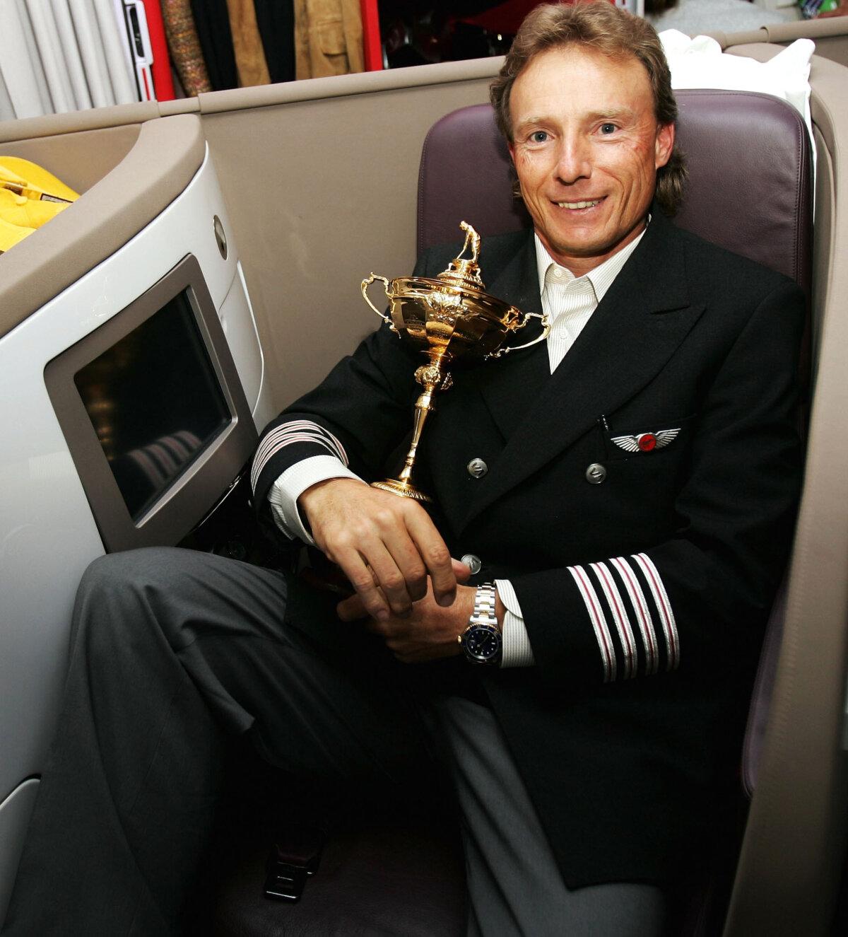 Bernhard Langer of Germany, the European Ryder Cup team captain, holds the Ryder Cup in the airplane on his way to Heathrow airport on Sept. 20, 2004. (Andrew Redington/Getty Images)