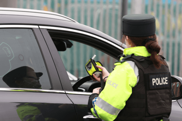 A police officer looking at a breathalyser at the launch of the 2022/23 police winter anti-drink/drug drive operation on Sydenham Road in Belfast, Northern Ireland, on Dec. 1, 2022. (PA Wire/PA Images)