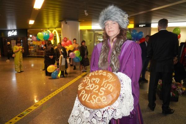 Maria presents the specially baked bread and salt to Shen Yun at Warsaw Chopin airport on Dec. 31, 2024. (Mary Man/The Epoch Times)