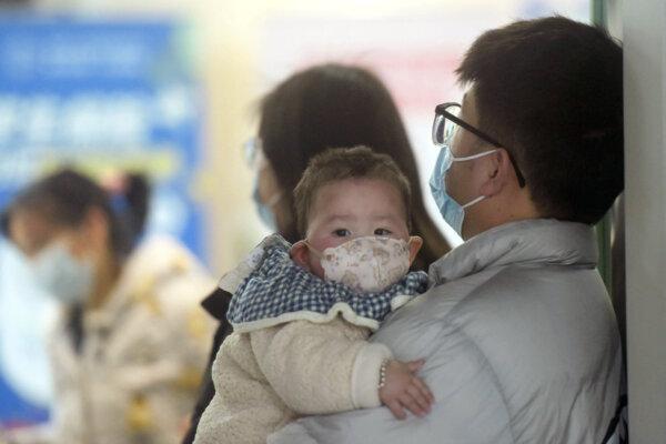 A baby wearing a face mask waits with family members at the pediatric department of a hospital in Hangzhou, Zhejiang Province, China, on Jan. 6, 2025. (AFP)