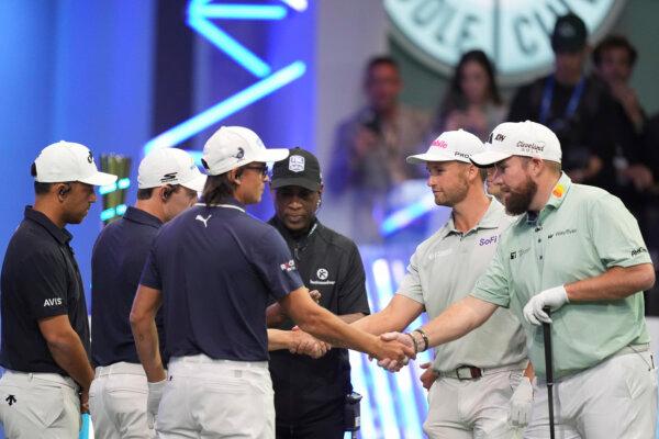 Rickie Fowler of New York Golf Club (3rd left) shakes hands with Shane Lowry of The Bay Golf Club as the teams prepare for the start of the inaugural match of the TGL golf league in Palm Beach Gardens, Fla., on Jan. 7, 2025. (Rebecca Blackwell/AP Photo)