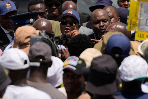 South Africa's police minister, Senzo Mchunu (C), attempts to talk to family members and activists after visiting an abandoned gold mine in Stilfontein, South Africa, on Jan. 14, 2025. (Themba Hadebe/AP)