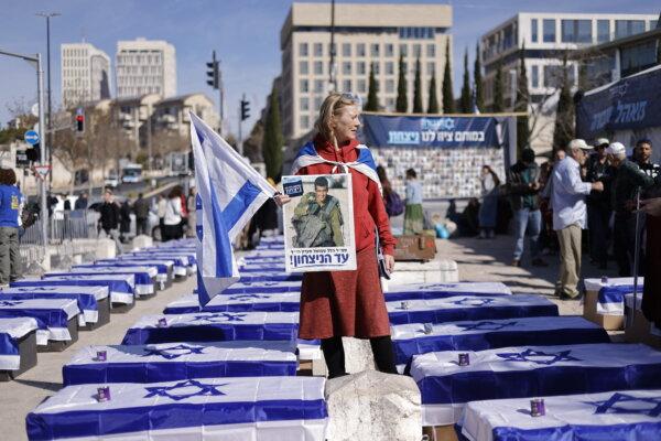 A demonstrator stands amid symbolic soldiers' coffins draped in Israeli flags to protest against the cease-fire with Hamas outside the Supreme Court in Jerusalem, Israel on Jan. 16, 2025. (John Vessels/AFP via Getty Images)