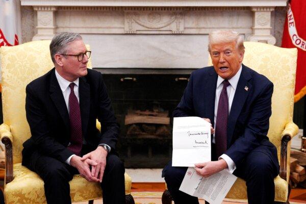 U.S. President Donald Trump holds a letter from Britain's King Charles III during a meeting with British Prime Minister Sir Keir Starmer in the Oval Office of the White House on Feb. 27, 2025. (Carl Court/Pool/AFP via Getty Images)