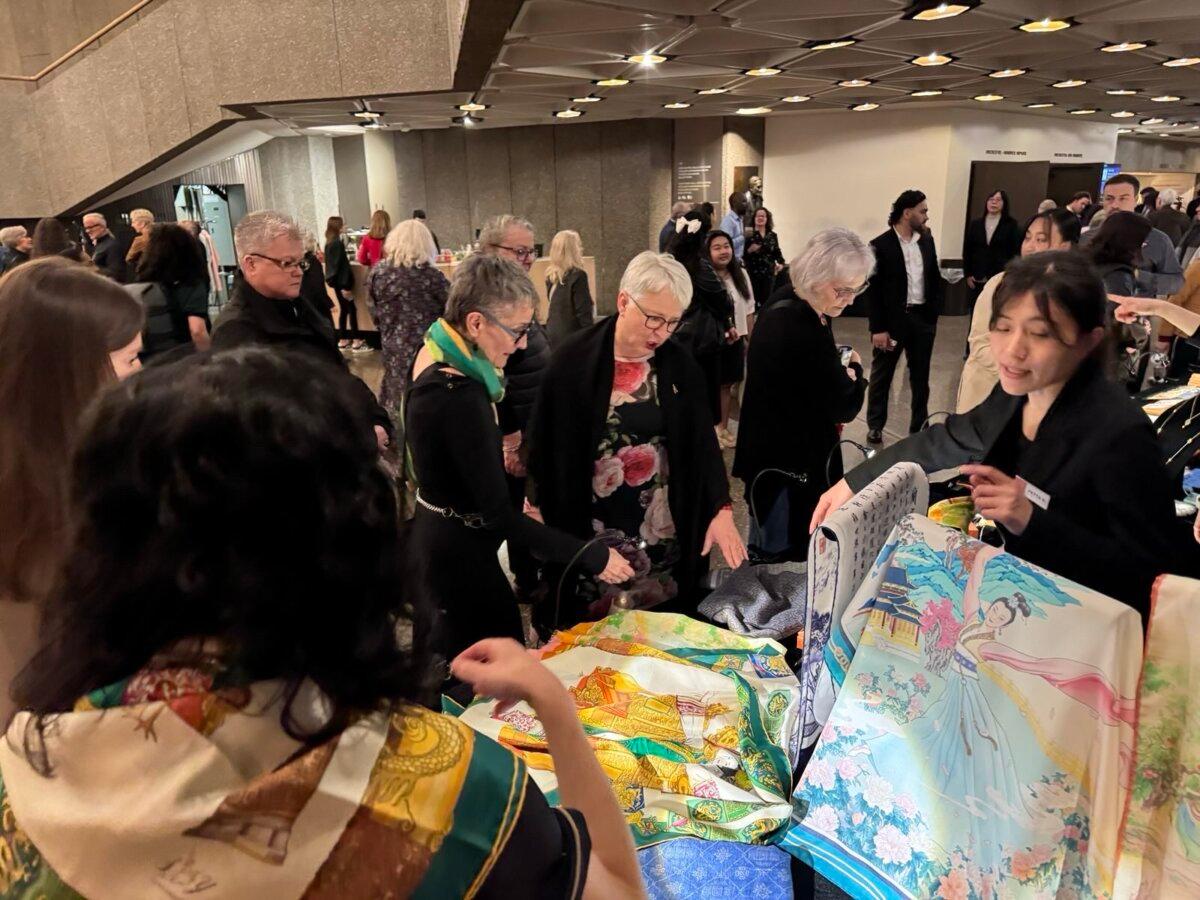 Lieutenant Governor of Ontario Edith Dumont checks out hand-painted scarves at a Shen Yun merchandise booth. (NTD)