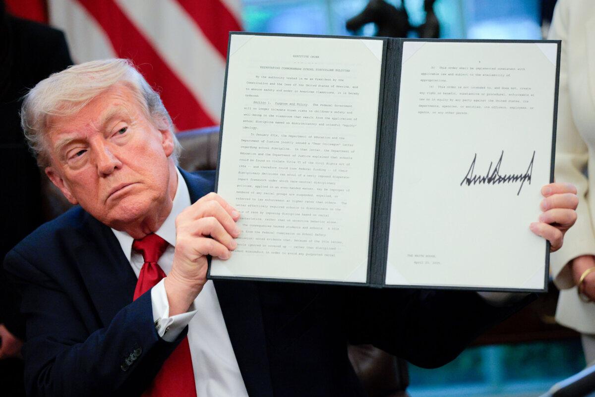 President Donald Trump displays a signed executive order titled "Reinstating Commonsense School Discipline Policies" in the Oval Office at the White House in Washington on April 23, 2025. (Chip Somodevilla/Getty Images)