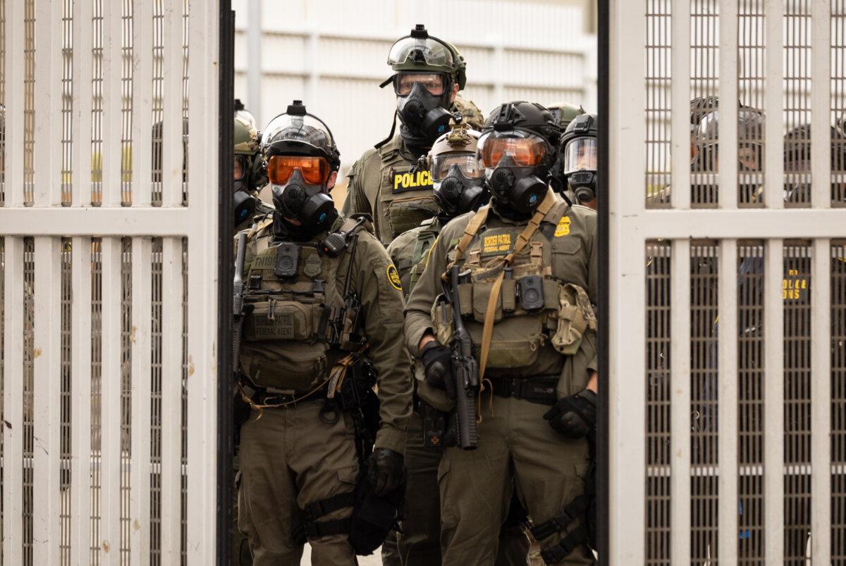 Federal agents stand inside the gates of the Immigration and Customs Enforcement compound in Portland, Ore., on Oct. 4, 2025. (John Fredricks/The Epoch Times)