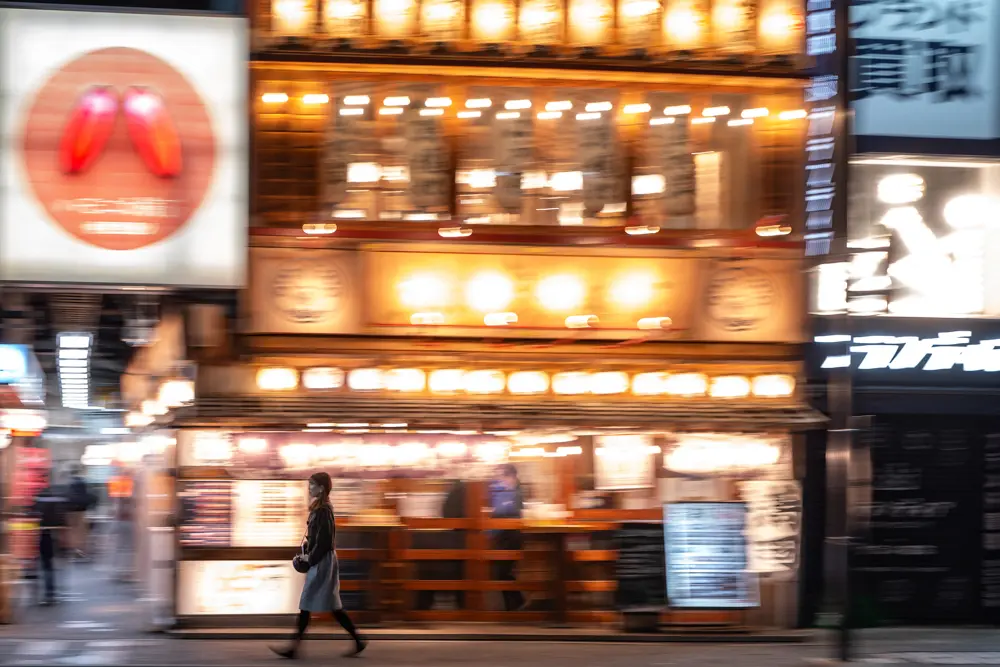 A woman walks past a restaurant area in Tokyo's Kichijoji district on March 16, 2026. (Philip Fong/AFP via Getty Images)