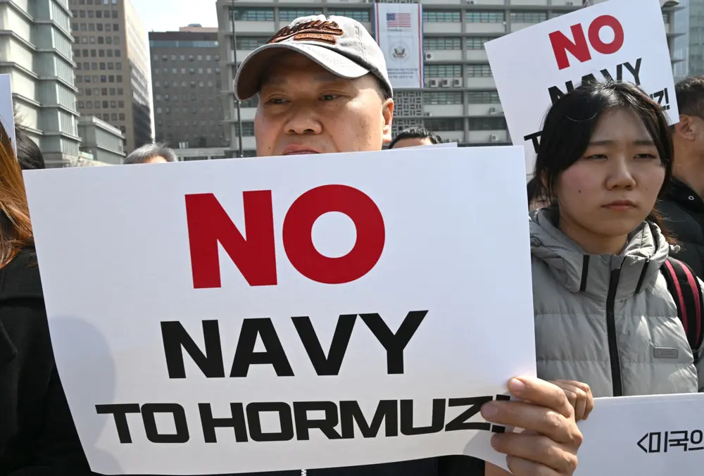 South Korean protesters hold placards during a protest against Trump's request to dispatch warships to the Strait of Hormuz in front of the US embassy in Seoul on March 16, 2026. (Jung Yeon-je / AFP via Getty Images)