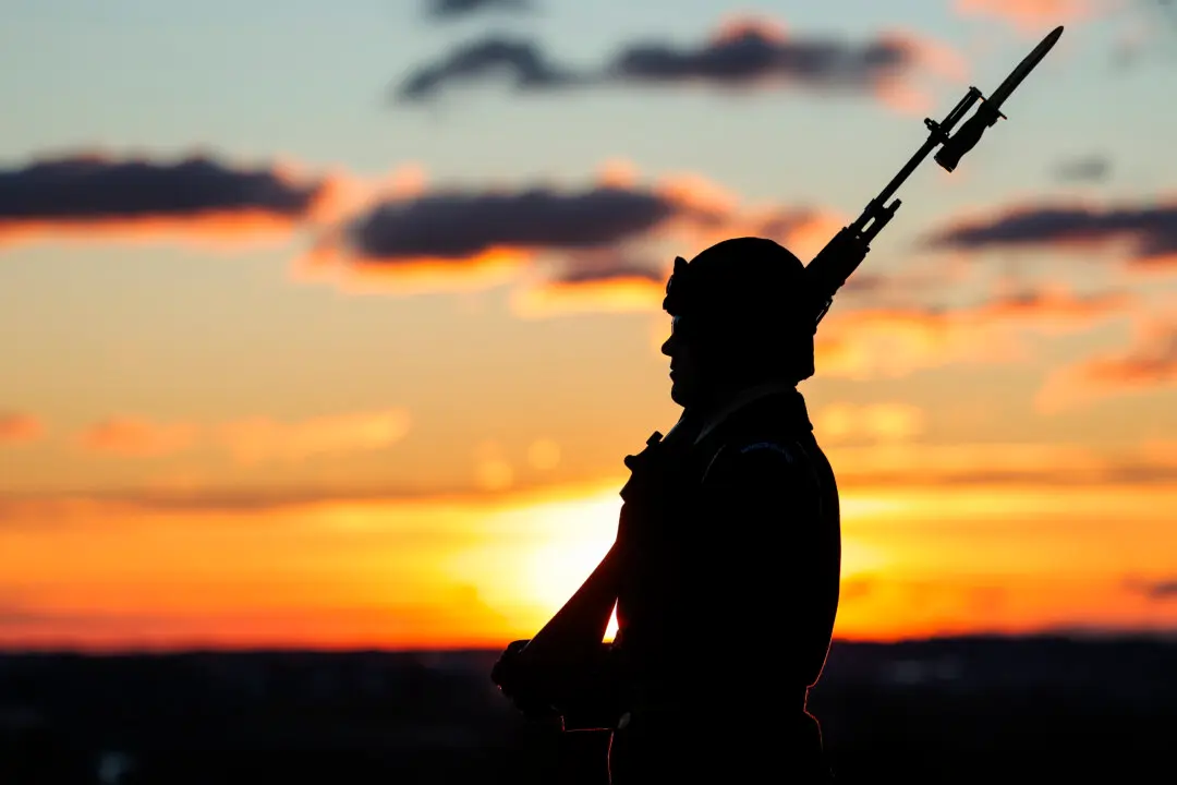 ARLINGTON, VIRGINIA - MARCH 17: A soldier guards the Tomb of the Unknown Soldier as the sun rises over Arlington National Cemetery on March 17, 2026 in Arlington, Virginia. March 25th will mark the centennial of the continuous military sentinel guarding the Tomb of the Unknown Soldier. (Photo by Heather Diehl/Getty Images)