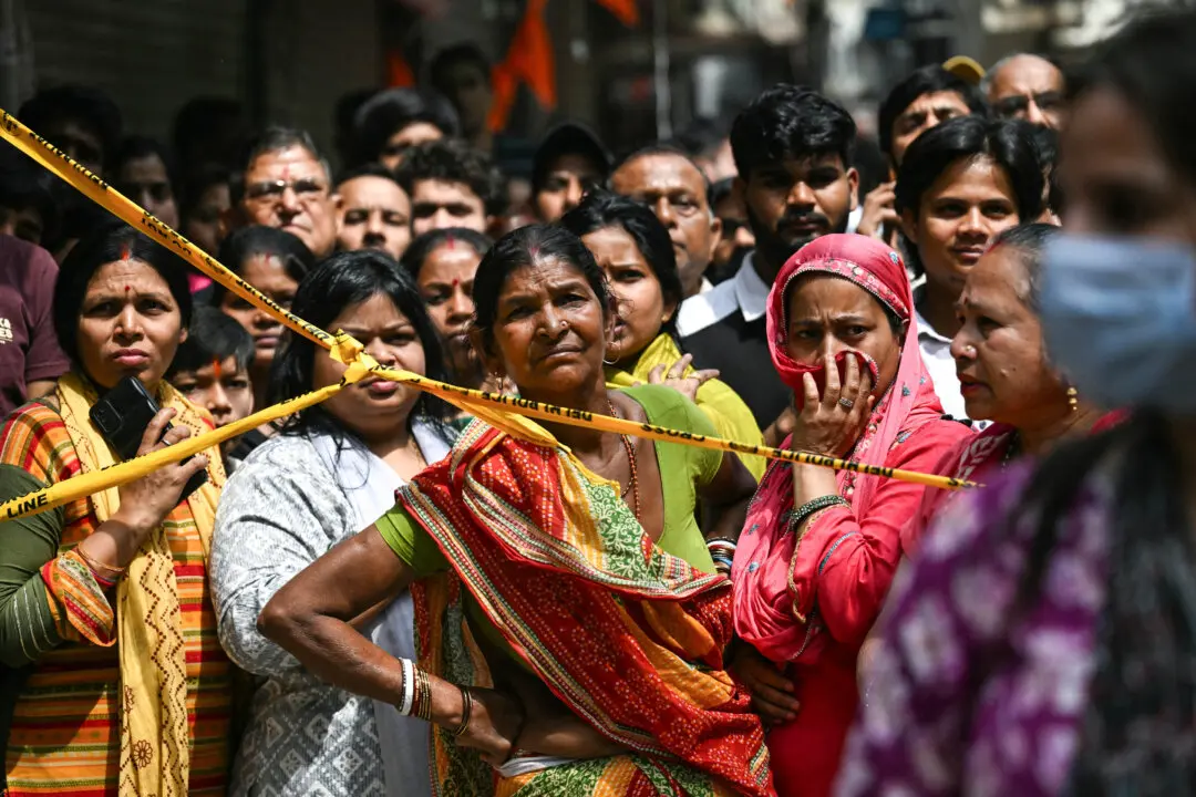 Onlookers gather after a fire broke out at a residential building in New Delhi, India, on March 18, 2026. (Arun Sankar / AFP via Getty Images)