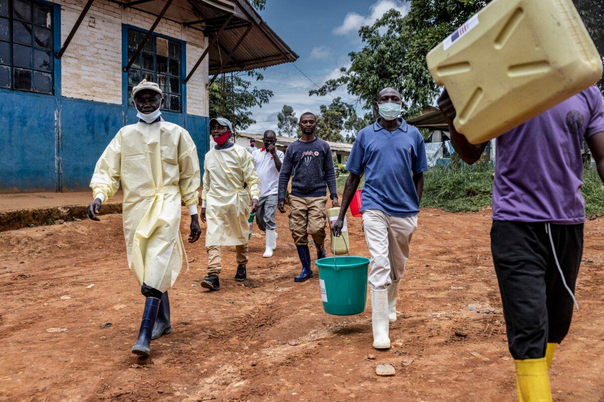 Health workers and local volunteers carry disinfectant containers and sanitation equipment outside the General Referral Hospital in Mongbwalu, Congo, on May 21, 2026. (Michel Lunanga/Getty Images)