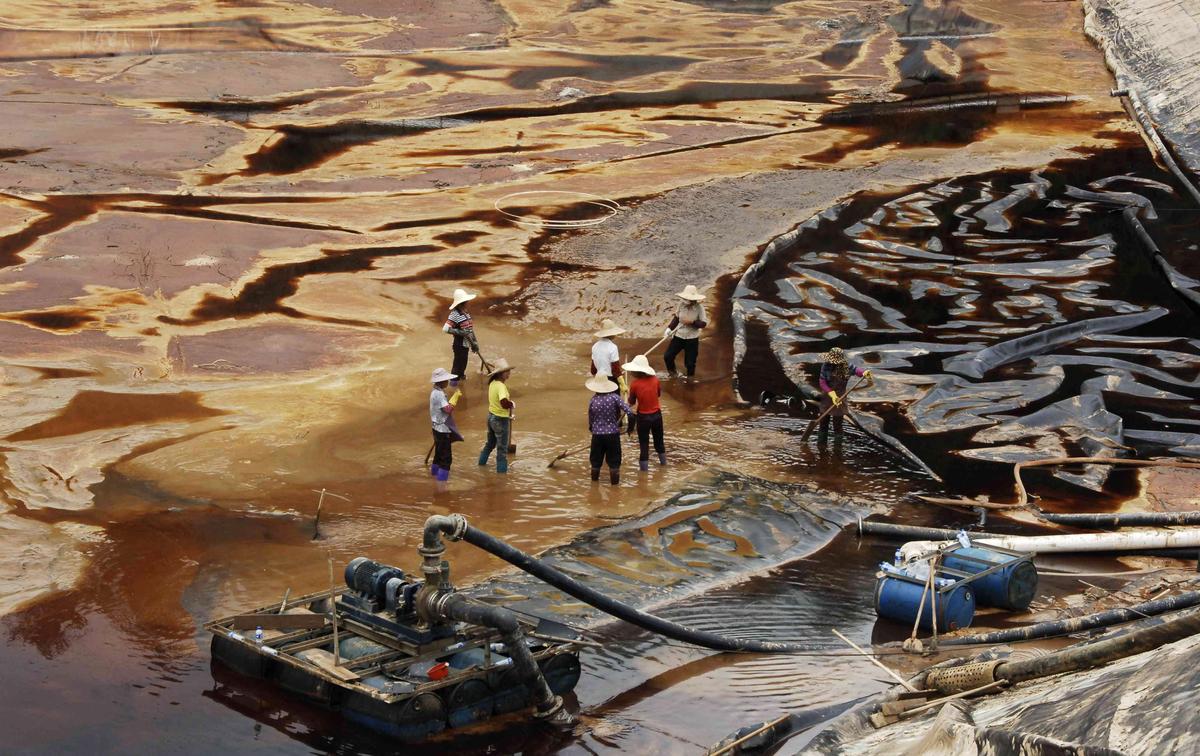 Workers drain away polluted water near the Zijin copper mine in Shanghang on July 13, 2010, after pollution from the mine contaminated the Ting River, a major waterway in southeast China's Fujian Province. (STR/AFP/Getty Images)
