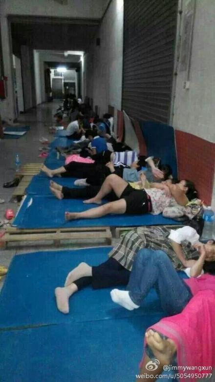 Workers sleep on the floor at the building of Dongguan Xing Hong Shoe Industry protesting to have their salaries paid, on Oct. 30, 2014. Owner of Dongguan Xing Hong has been missing for days with 700 workers unpaid for two months. (Weibo.com)