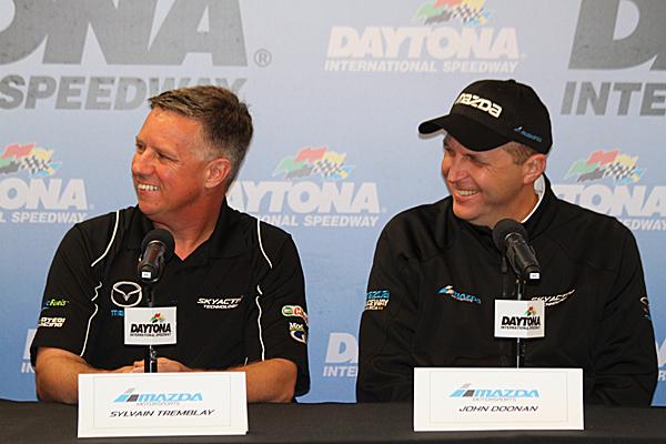 SpeedSource owner/driver Sylvain Tremblay (L) and Mazda Motorsports Director John Doonan talk about the improved 2015 Mazda diesel prototypes at the Roar Before the 24, Jan. 9 at Daytona International Speedway. (Chris Jasurek/Epoch Times)