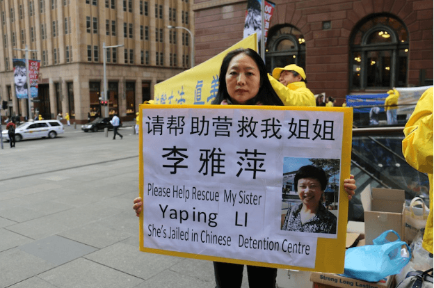 Mrs Ying Li holds a placard asking for the public's help to rescue her sister, Yaping Li, who was illegally arrested five months ago, in China, for practising Falun Gong. (Melanie Sun/Epoch Times)