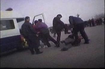 Plain-clothes police kick a Falun Gong practitioner in Tiananmen Square, Beijing as another is forced into a waiting police van in a clip from the upcoming CBC documentary Beyond the Red Wall: The Persecution of Falun Gong. (CBC)