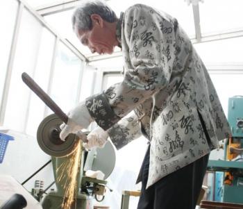 Chen demonstrates how he grinds the steel bars into swords in his workshop. It is a long and arduous process. The slightest of errors can ruin the blade, which would otherwise fetch thousands of dollars. (Matthew Robertson/The Epoch Times)