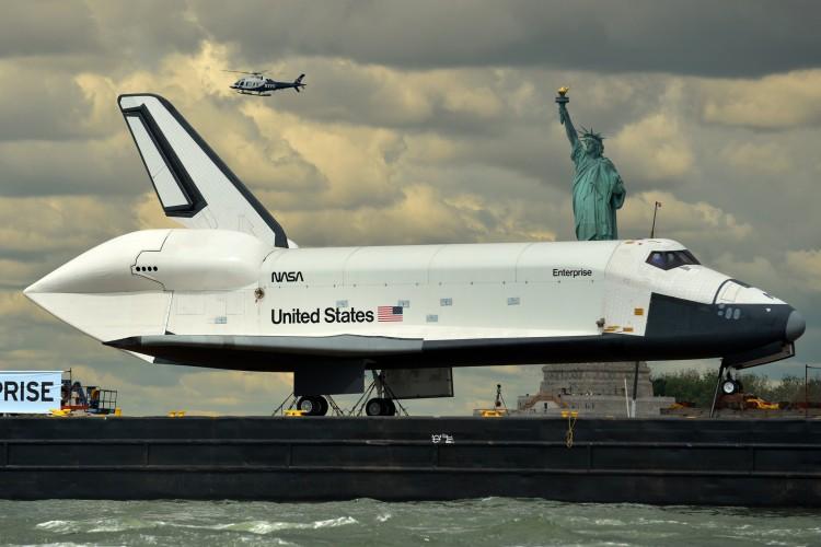 <a><img class="size-large wp-image-1786542" title="The space shuttle Enterprise is towed by" src="https://www.theepochtimes.com/assets/uploads/2015/09/145805857_shuttle.jpg" alt="The space shuttle Enterprise is towed by barge past the Statue of Liberty June 6 on its way to the Intrepid Sea, Air and Space Museum where it will be permanently displayed. (Stand Honda/AFP/Getty Images " width="590" height="393"/></a>