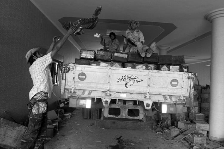 <a><img class="size-medium wp-image-1795375" title="Libyan National Transitional Council (NTC) fighters load a truck with weapons after finding a cache inside a house in the village of Qasr Abu Hadi, the birthplace of Moammar Gadhafi. (Ahmad Al-Rubaye/Afp/Getty Images)" src="https://www.theepochtimes.com/assets/uploads/2015/09/20111003BW.jpg" alt="Libyan National Transitional Council (NTC) fighters load a truck with weapons after finding a cache inside a house in the village of Qasr Abu Hadi, the birthplace of Moammar Gadhafi. (Ahmad Al-Rubaye/Afp/Getty Images)" width="575"/></a>