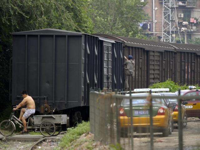 <a><img class="size-large wp-image-1782824" title="89648037_Freight_train" src="https://www.theepochtimes.com/assets/uploads/2015/09/89648037_Freight_train.jpeg" alt="A man rides a tricycle over the rails next to a cargo train in Beijing " width="590" height="442"/></a>